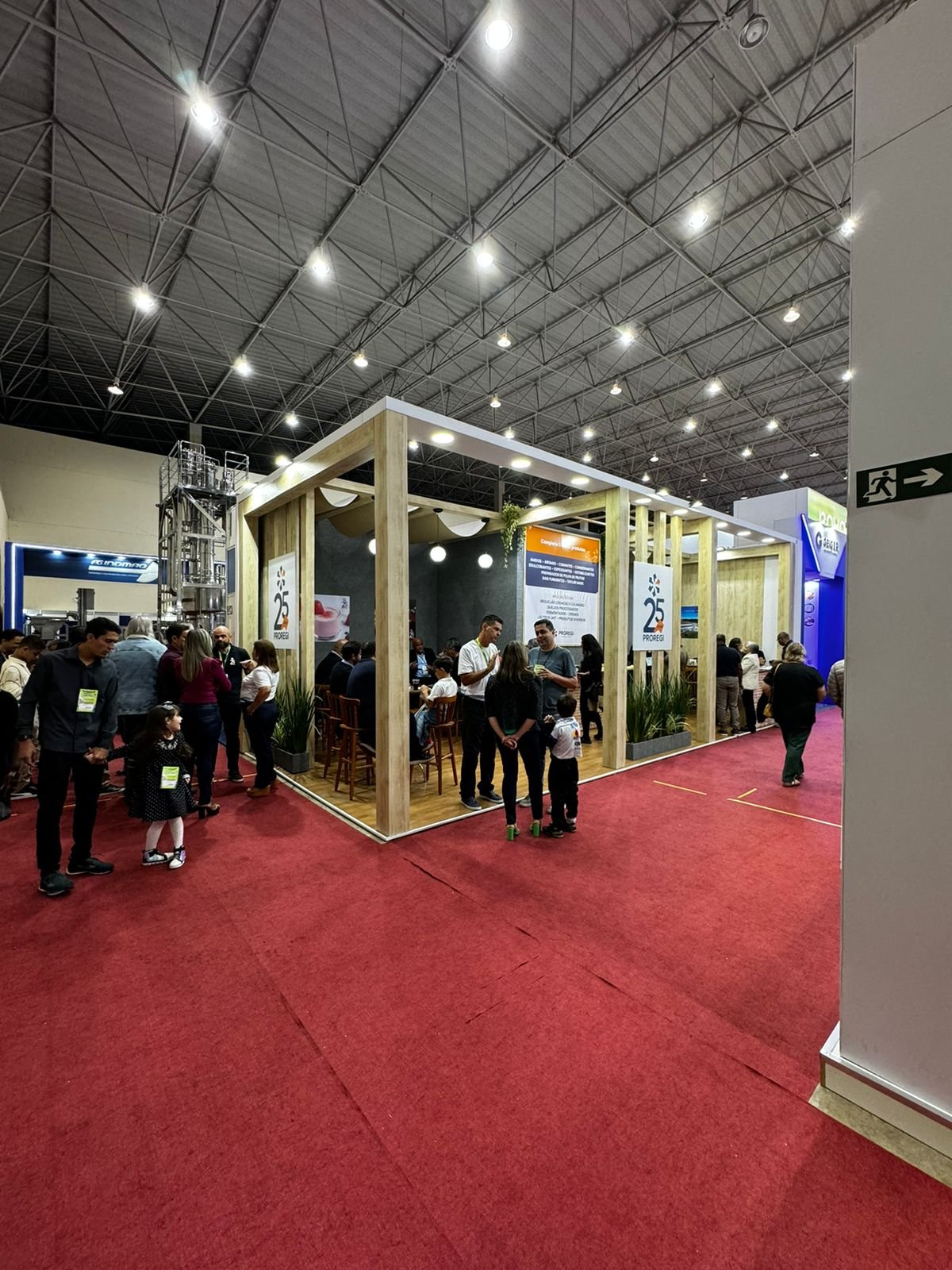 Estande da Proregi em pavilhão industrial com vitrine de produtos e balcão